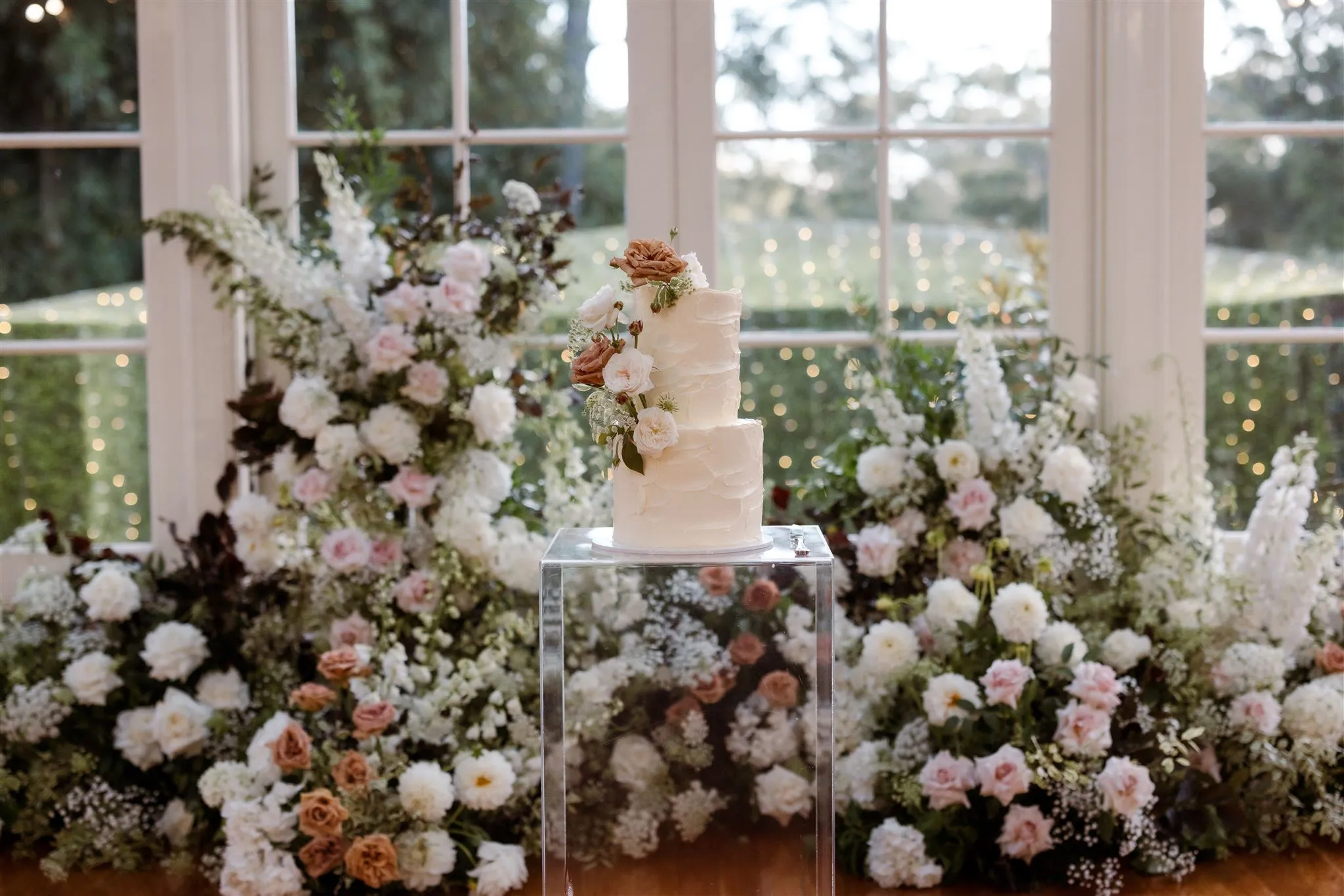 Wedding cake with flowers behind