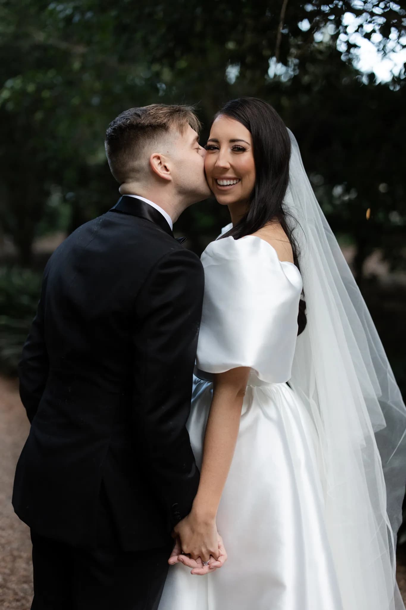 Groom kissing bride on cheek