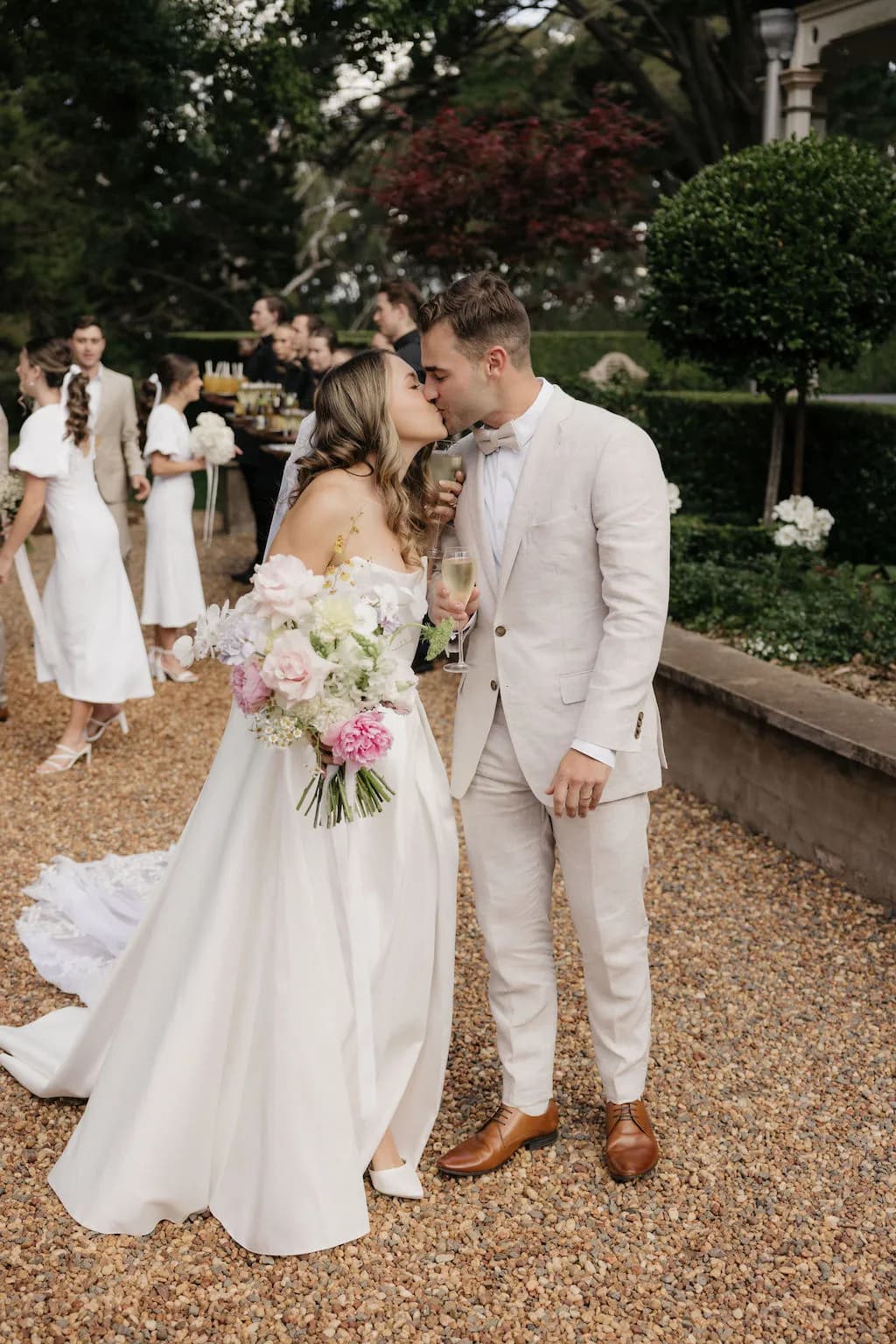 Bride and groom kissing holding champagne