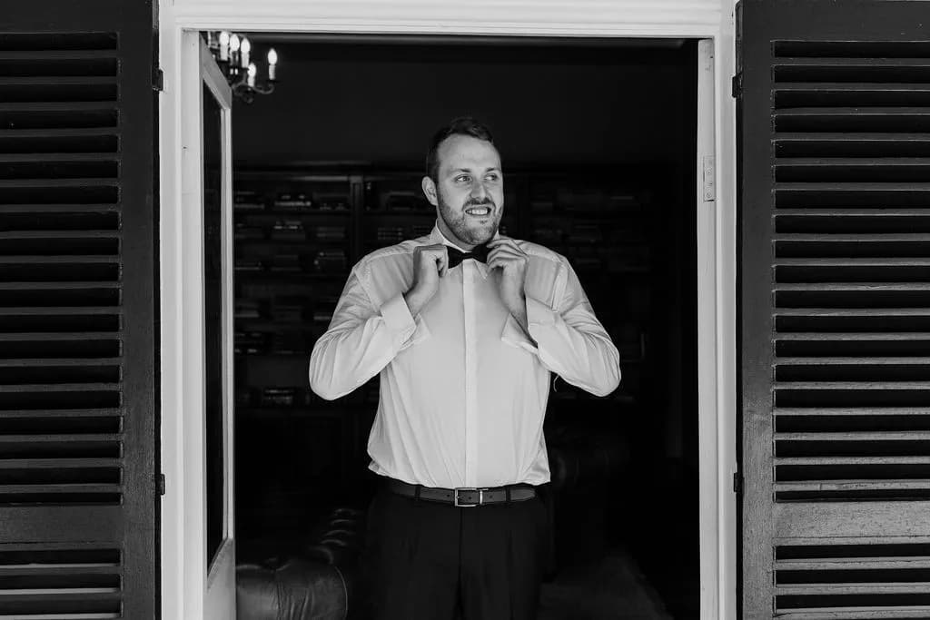 Groom doing up bowtie