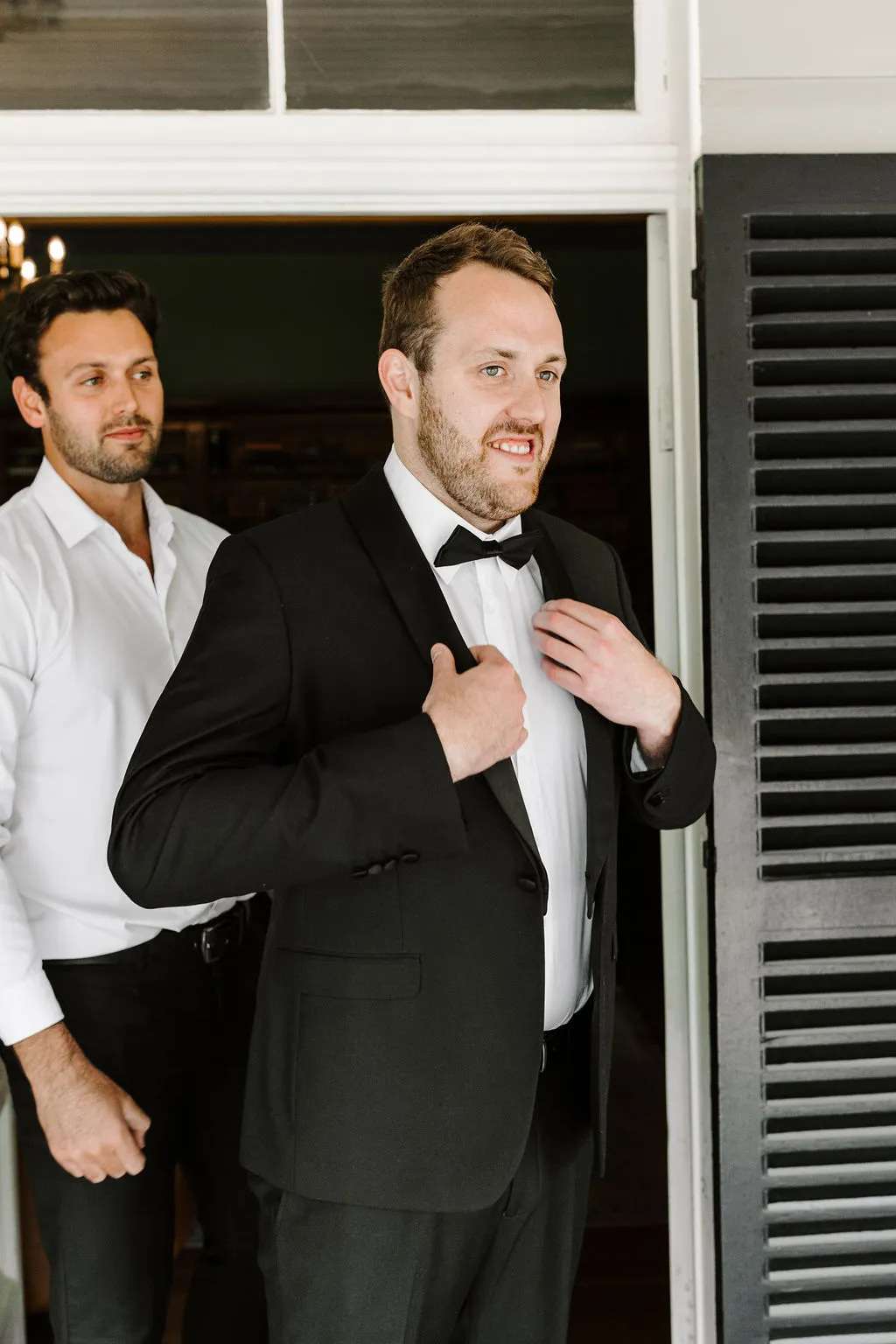 Groom putting on jacket