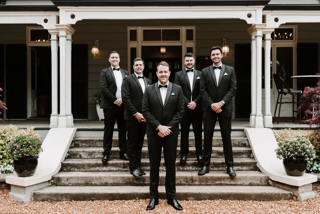 Groom standing on steps with groomsmen