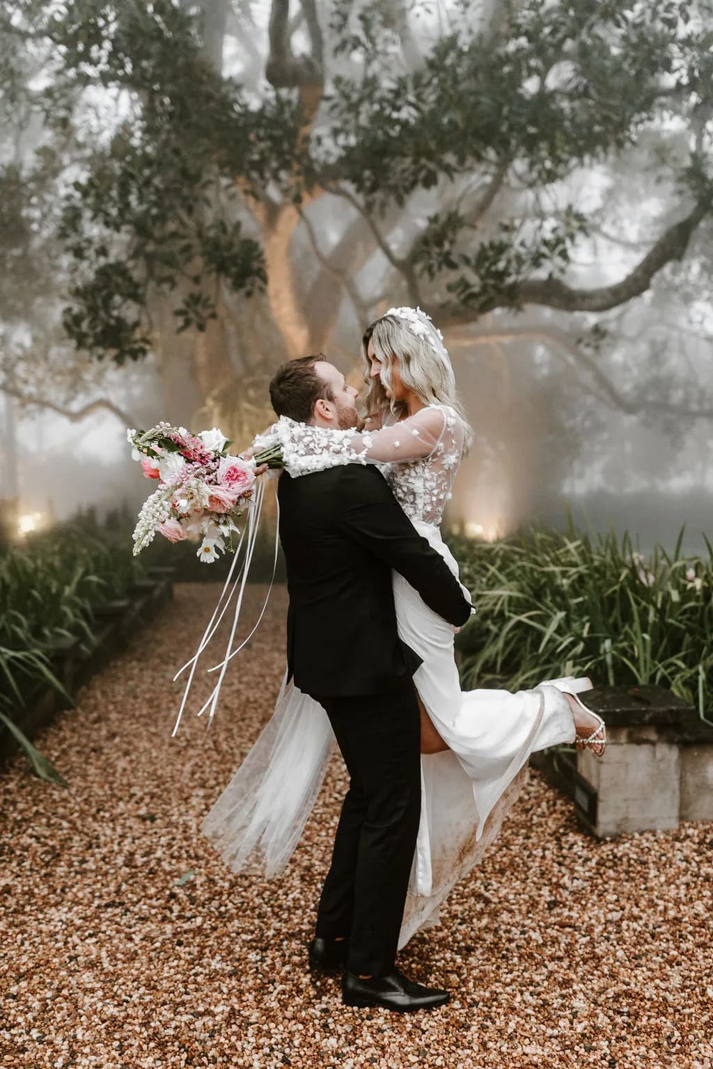Bride holding groom and twirling her around