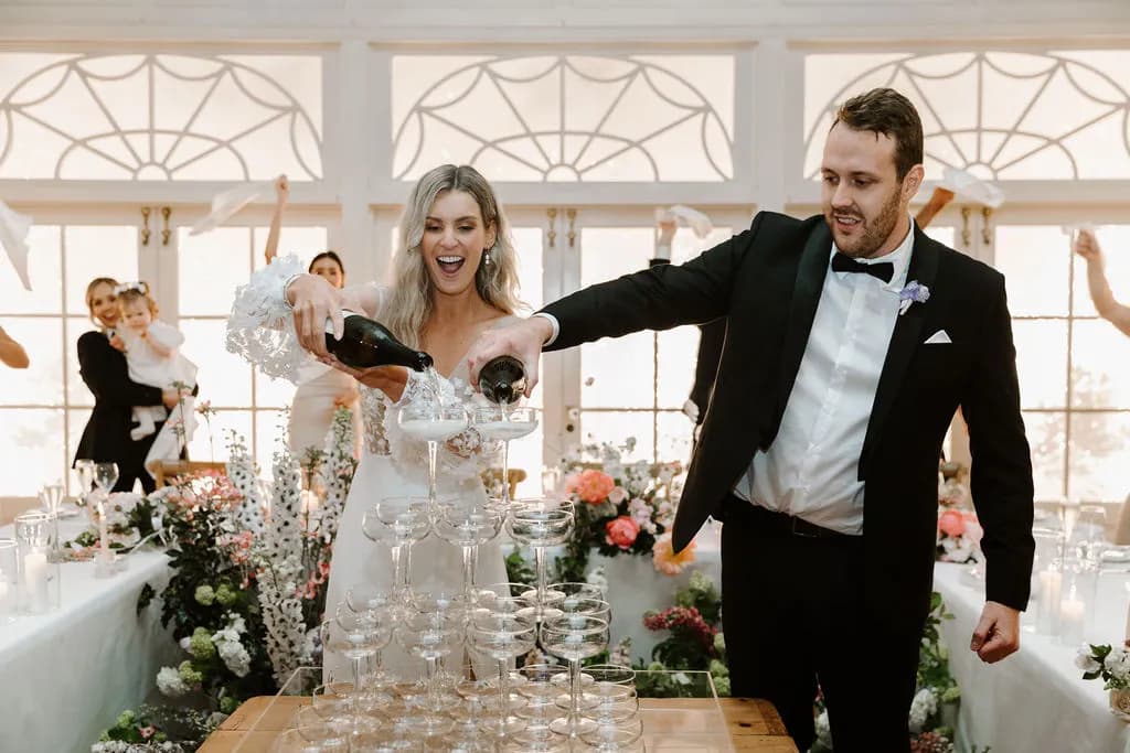 Bride and groom puring champagne tower