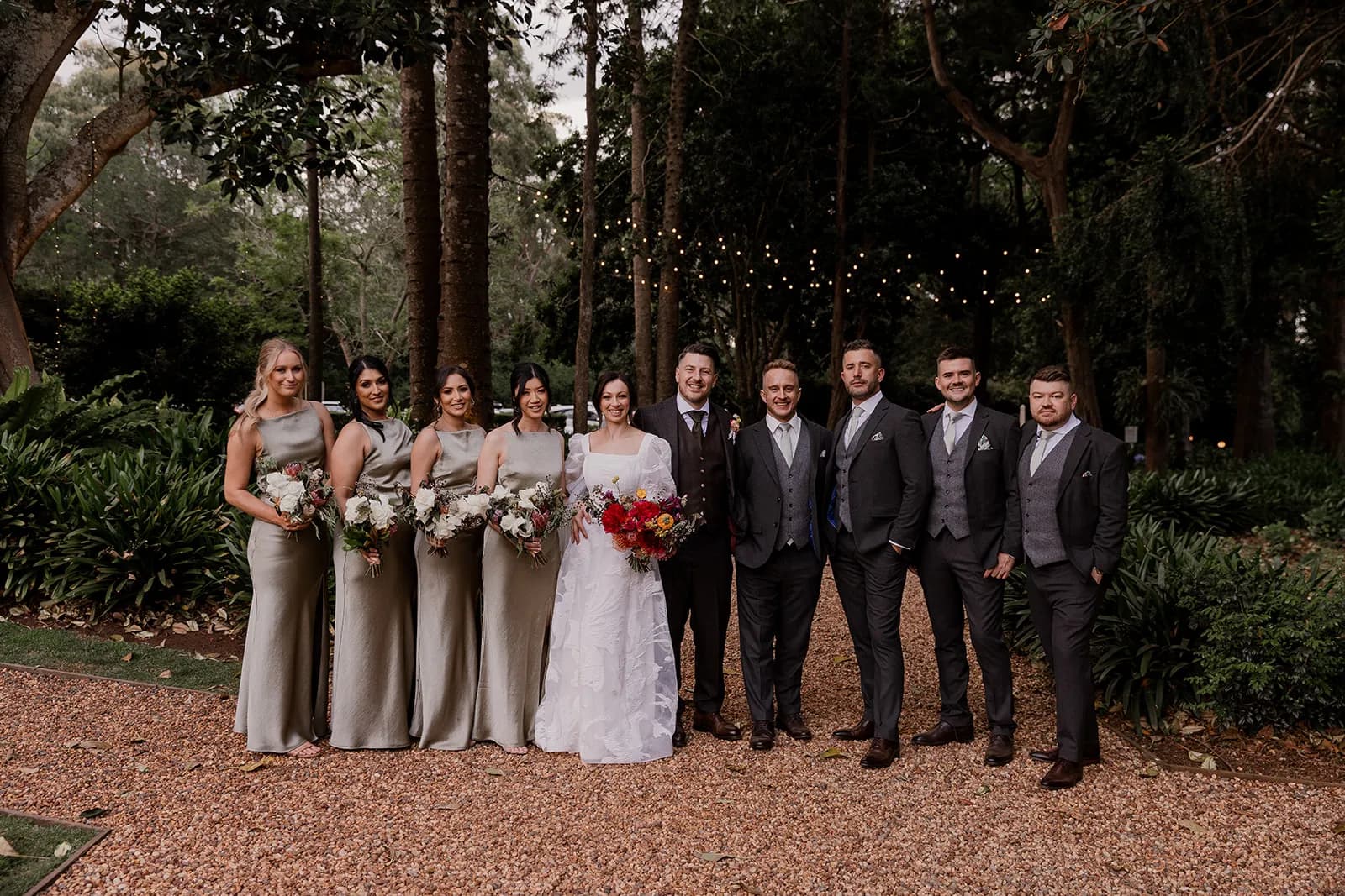 Wedding party standing on pebble driveway