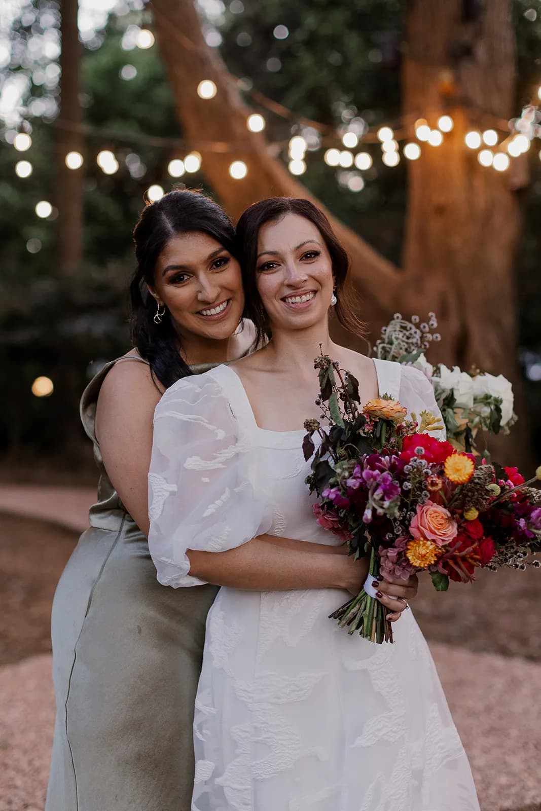 Bride and bridesmaid hugging