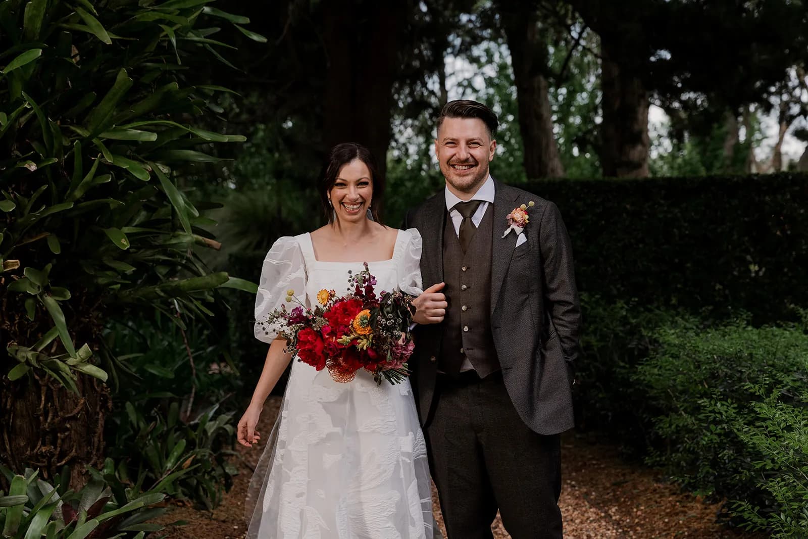 Bride and groom standing in gardens