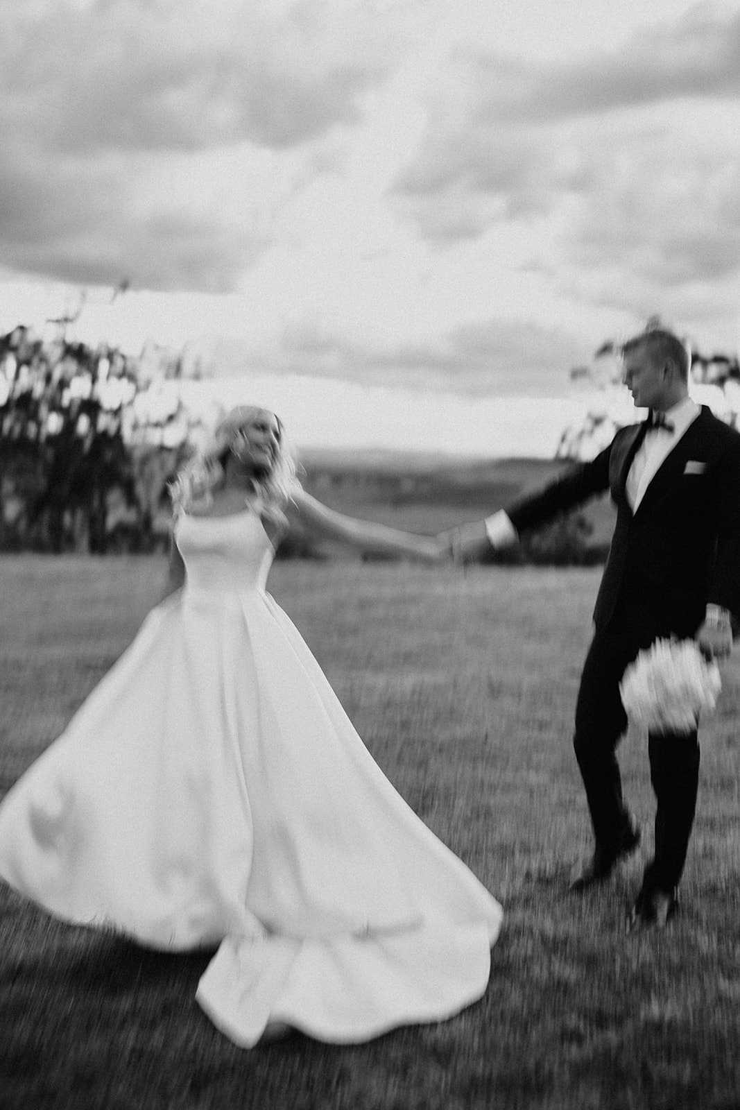 Bride and groom walking through fields