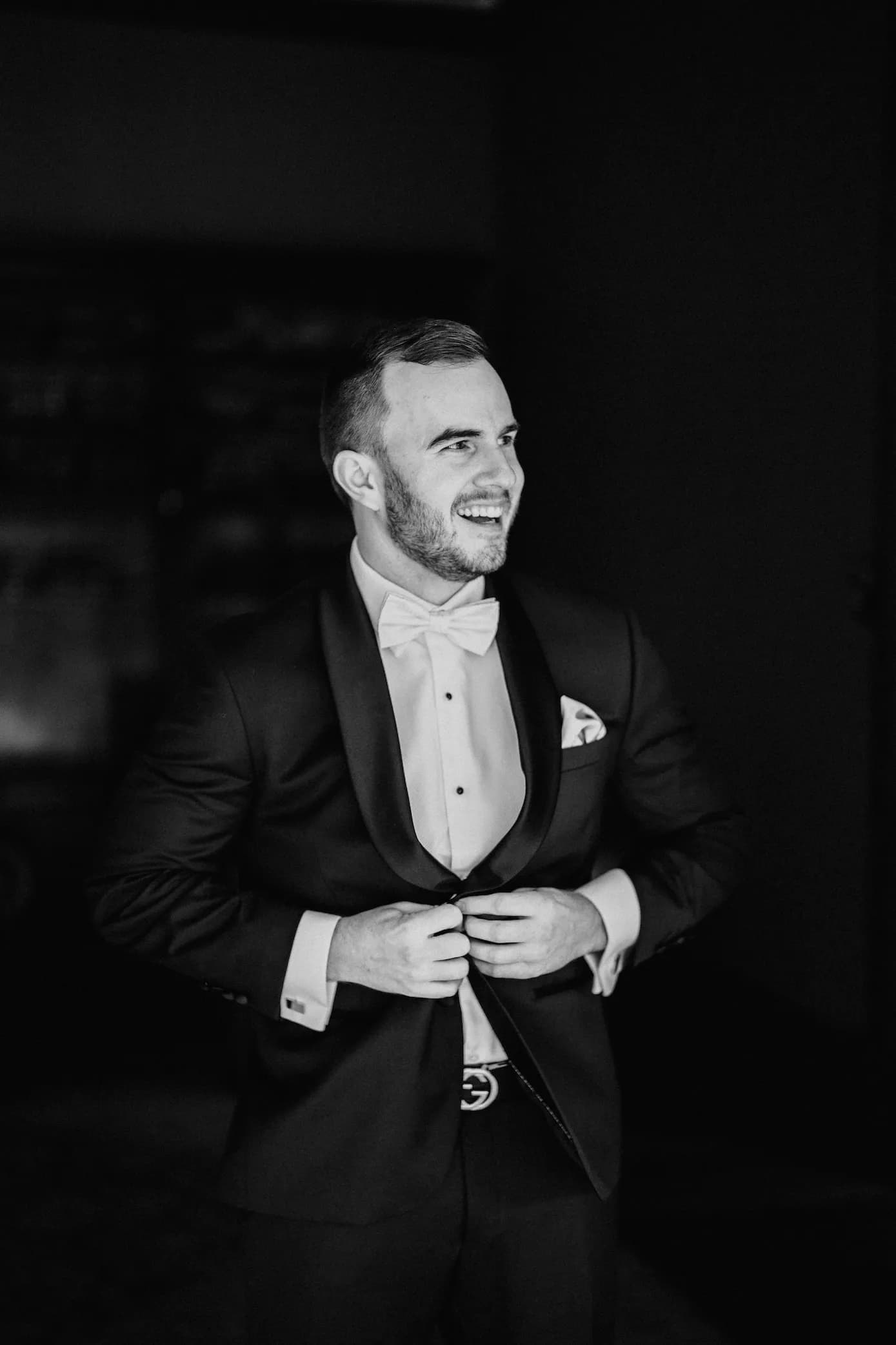 Groom buttoning suit up
