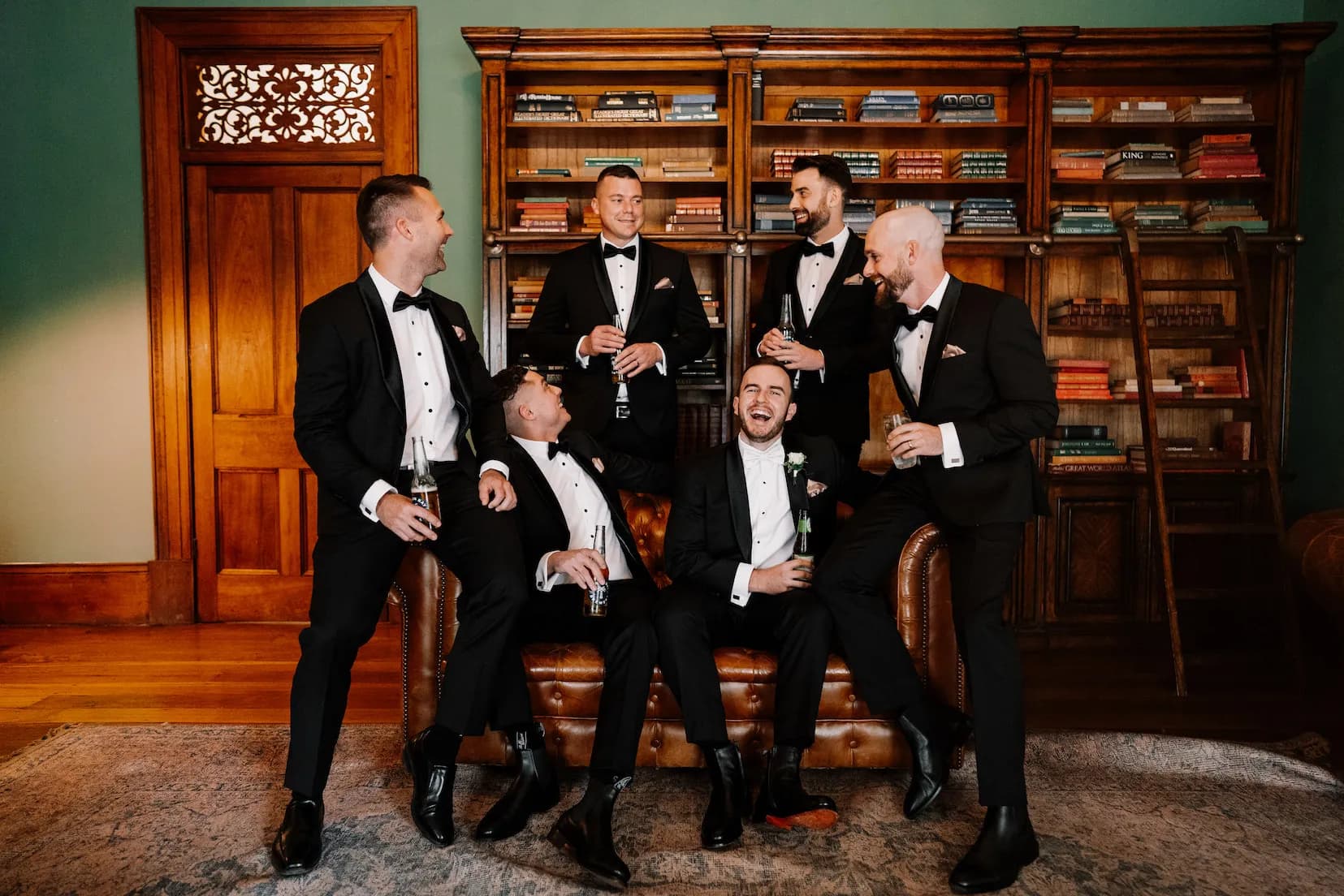 Groom and groomsmen sitting in library