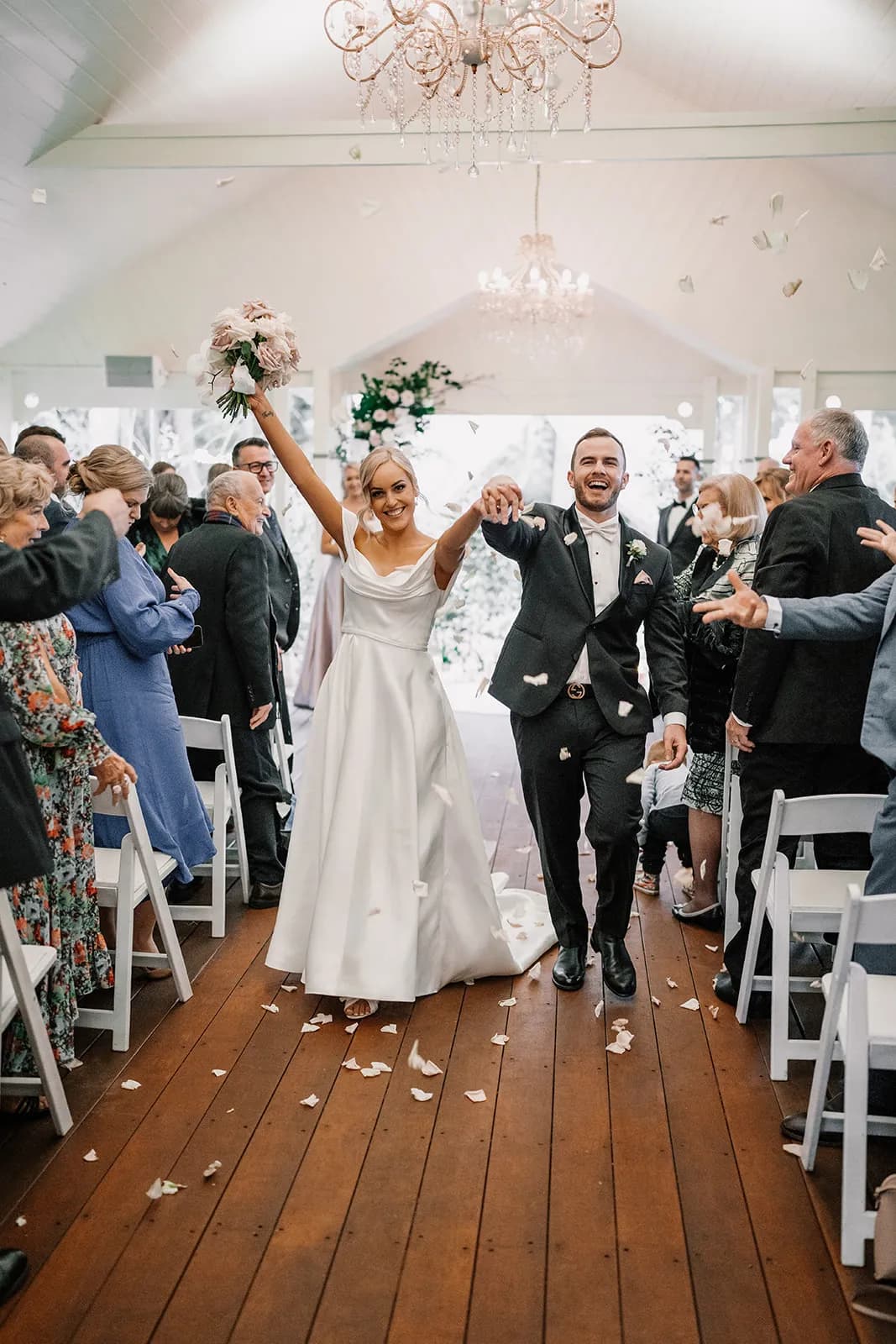 Bride and groom holding hands walking down the aisle