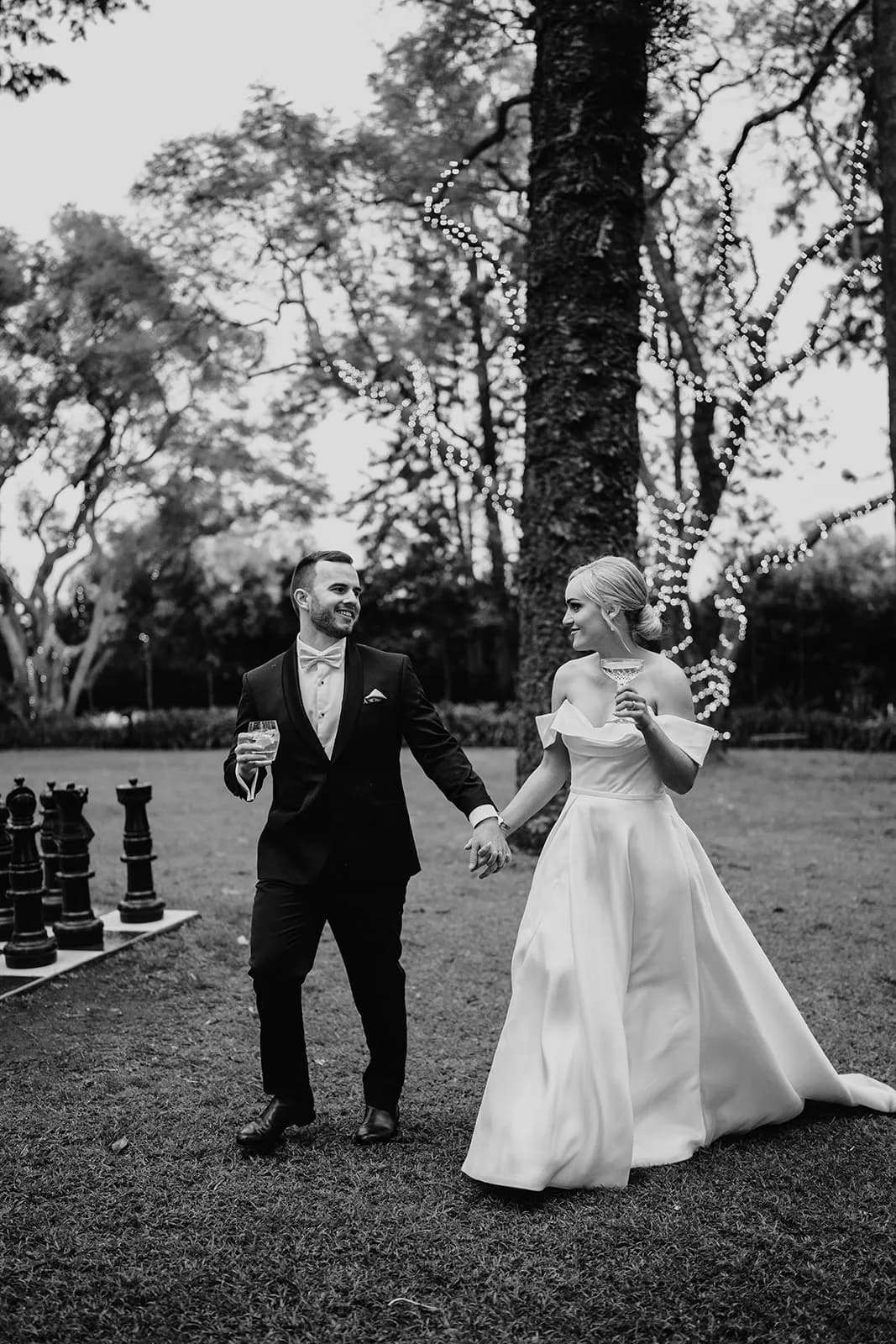Bride and groom walking through gardens