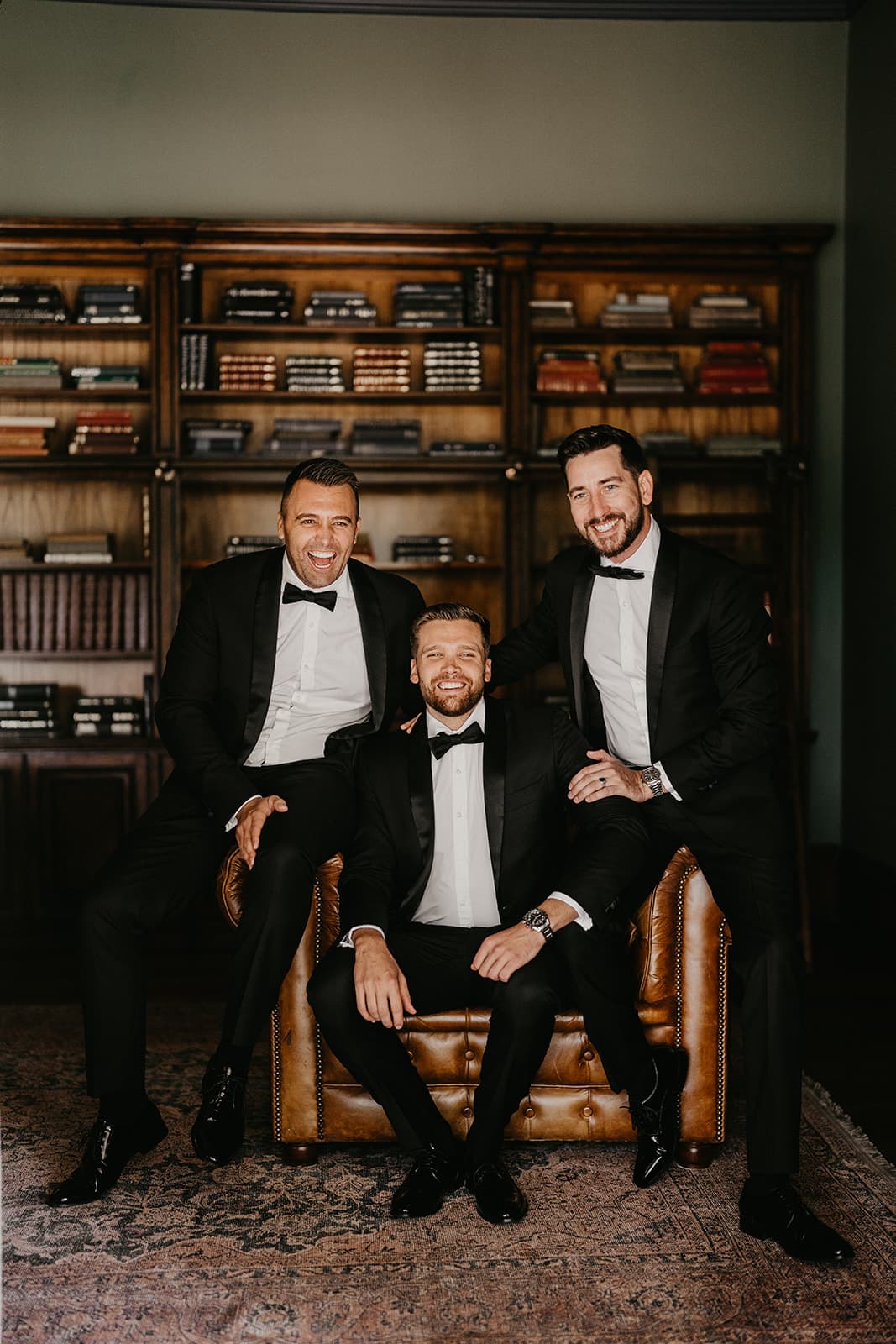 Groom and groomsman sitting on chair