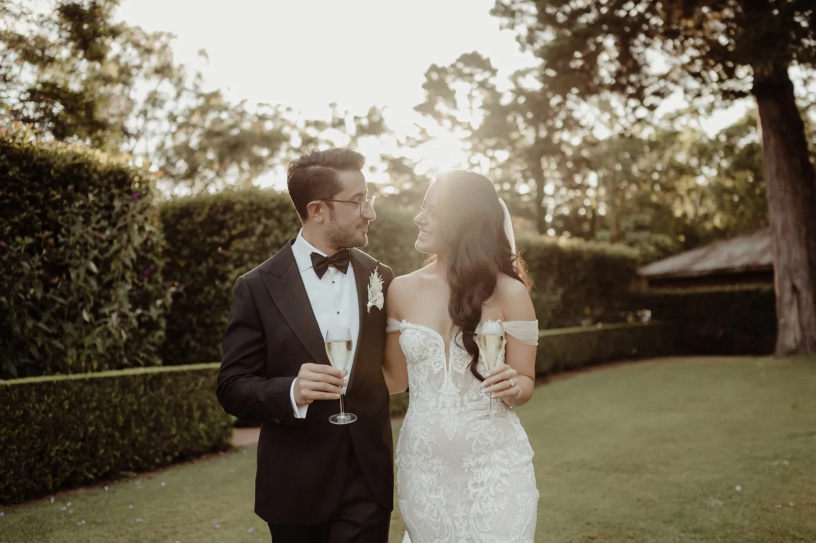 Bride and groom walking through gardens