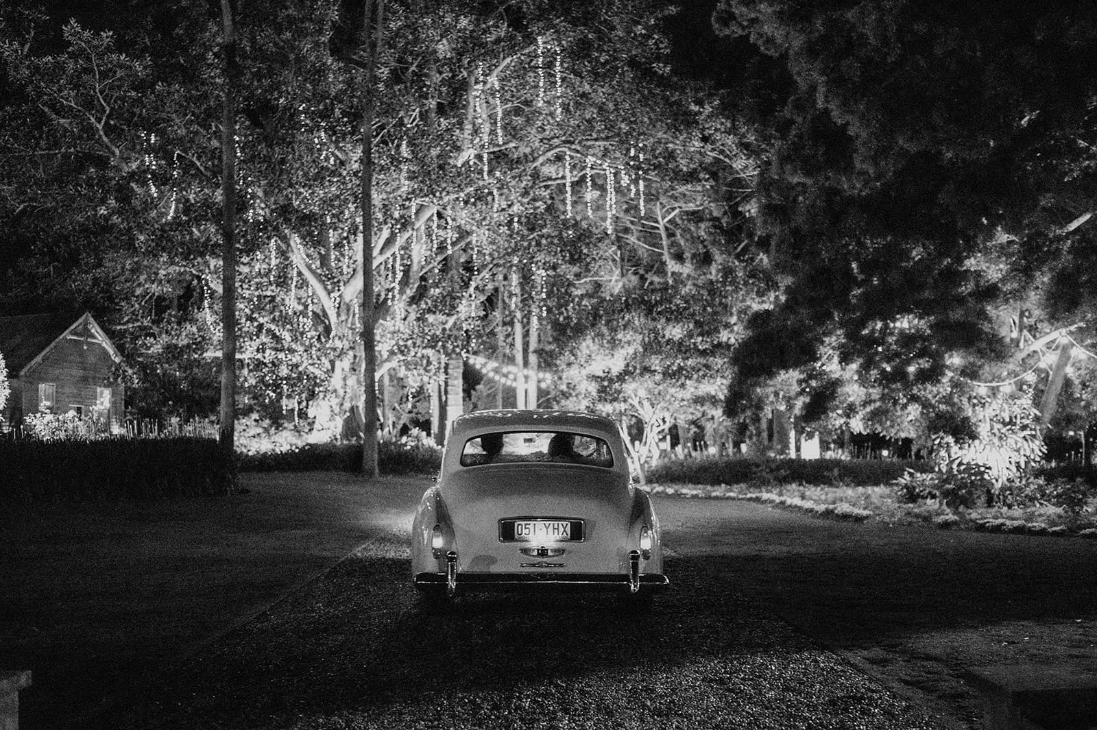 Bride and groom diriving away in car