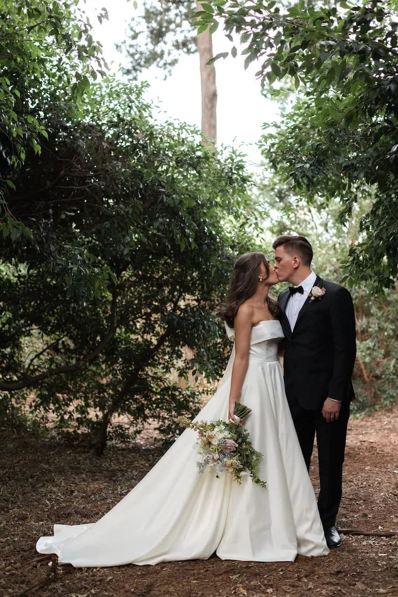 Bride and groom kissing in gardens