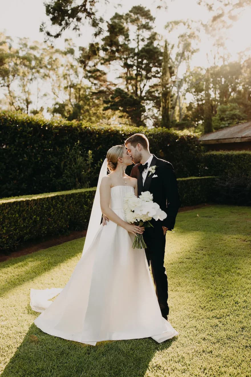 Bride and groom kissing in gardens