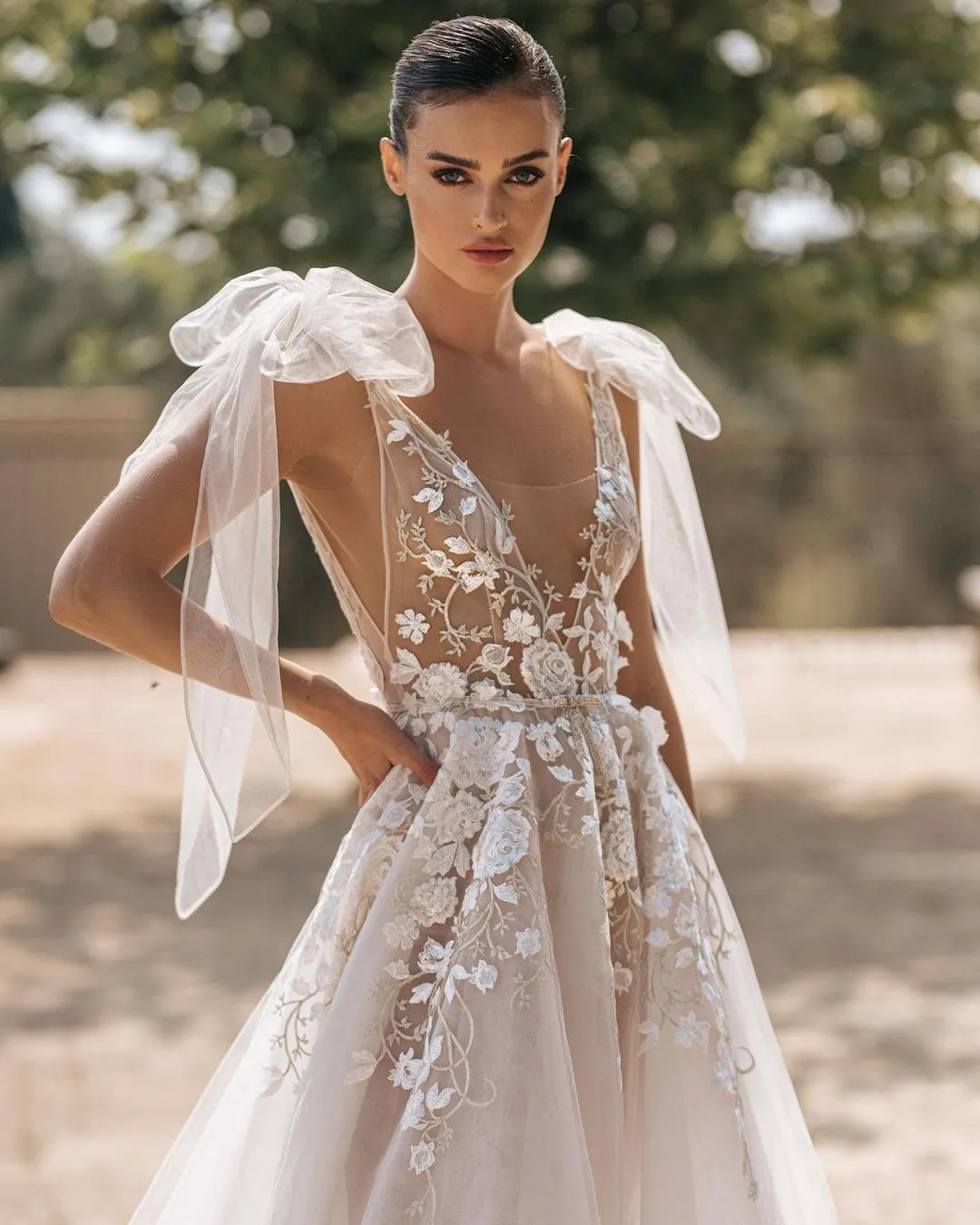 Bride wearing wedding dress with big sheer bow sleeve