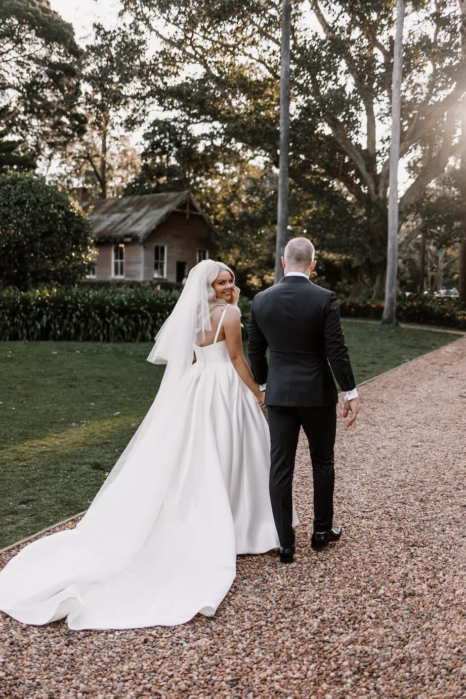 Bride and groom walking down driveway