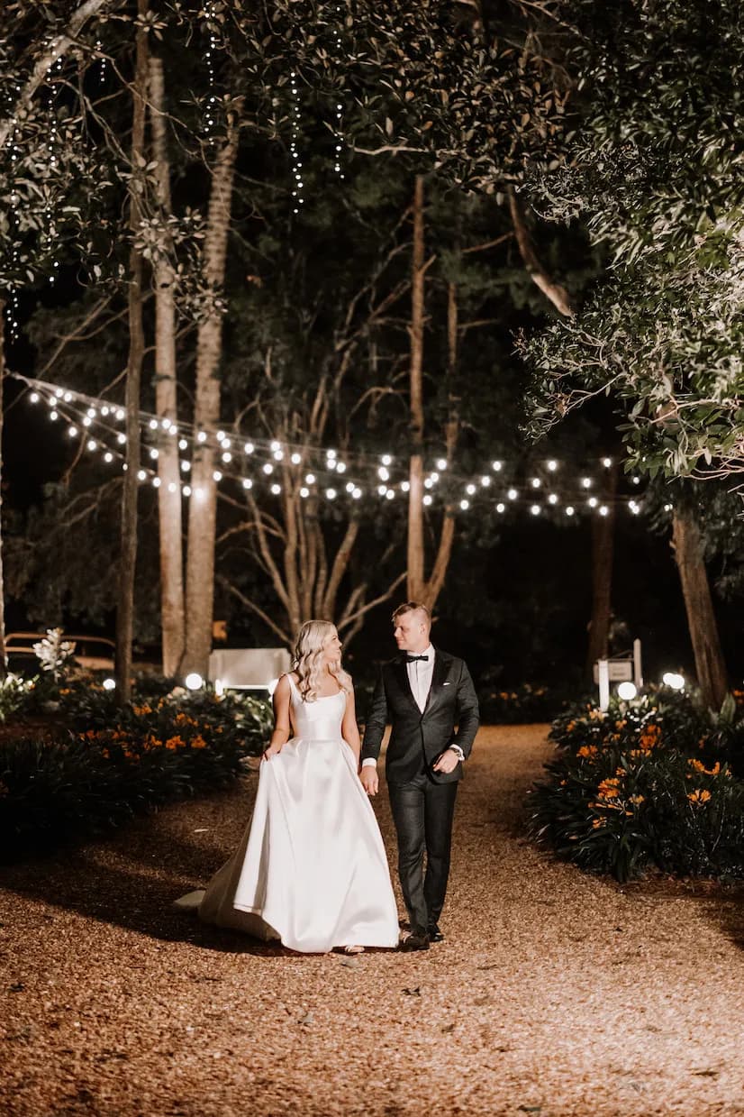 Bride and groom walking down path