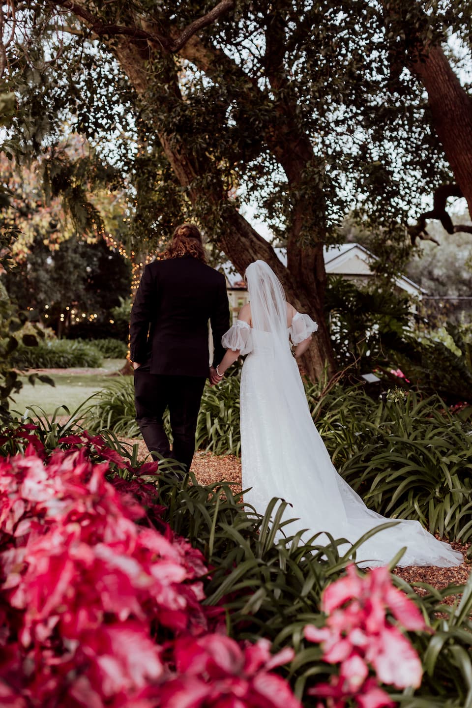 Bride and groom walking through gardens