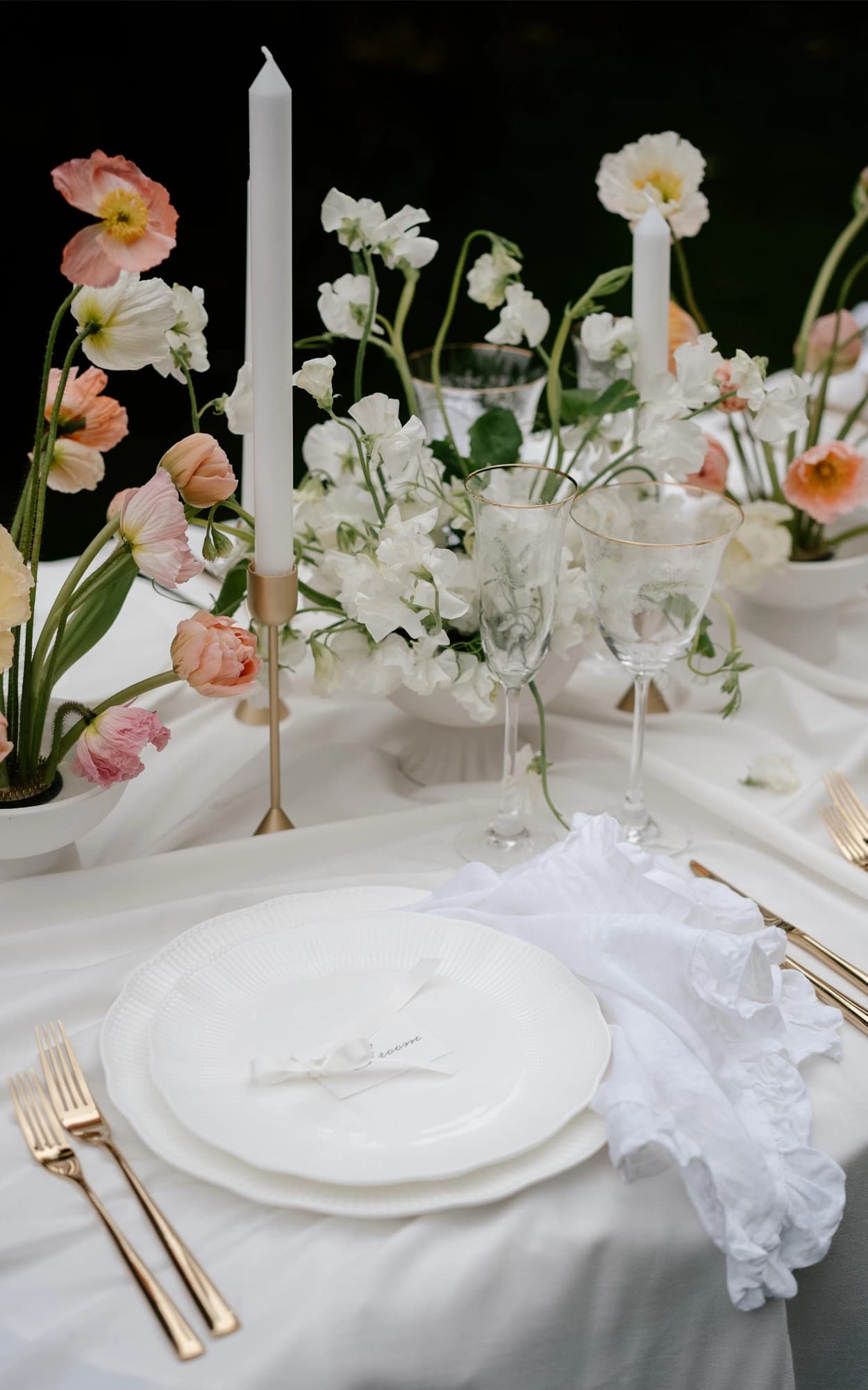 Elegant table setting featuring white and gold plates with coordinated place settings, creating a sophisticated dining atmosphere.